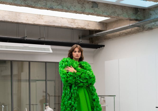 Cappotto over completamente ricamato di piume e pantaloni di faille di seta, GIAMBATTISTA VALLI HAUTE COUTURE; orecchini, VILTIER