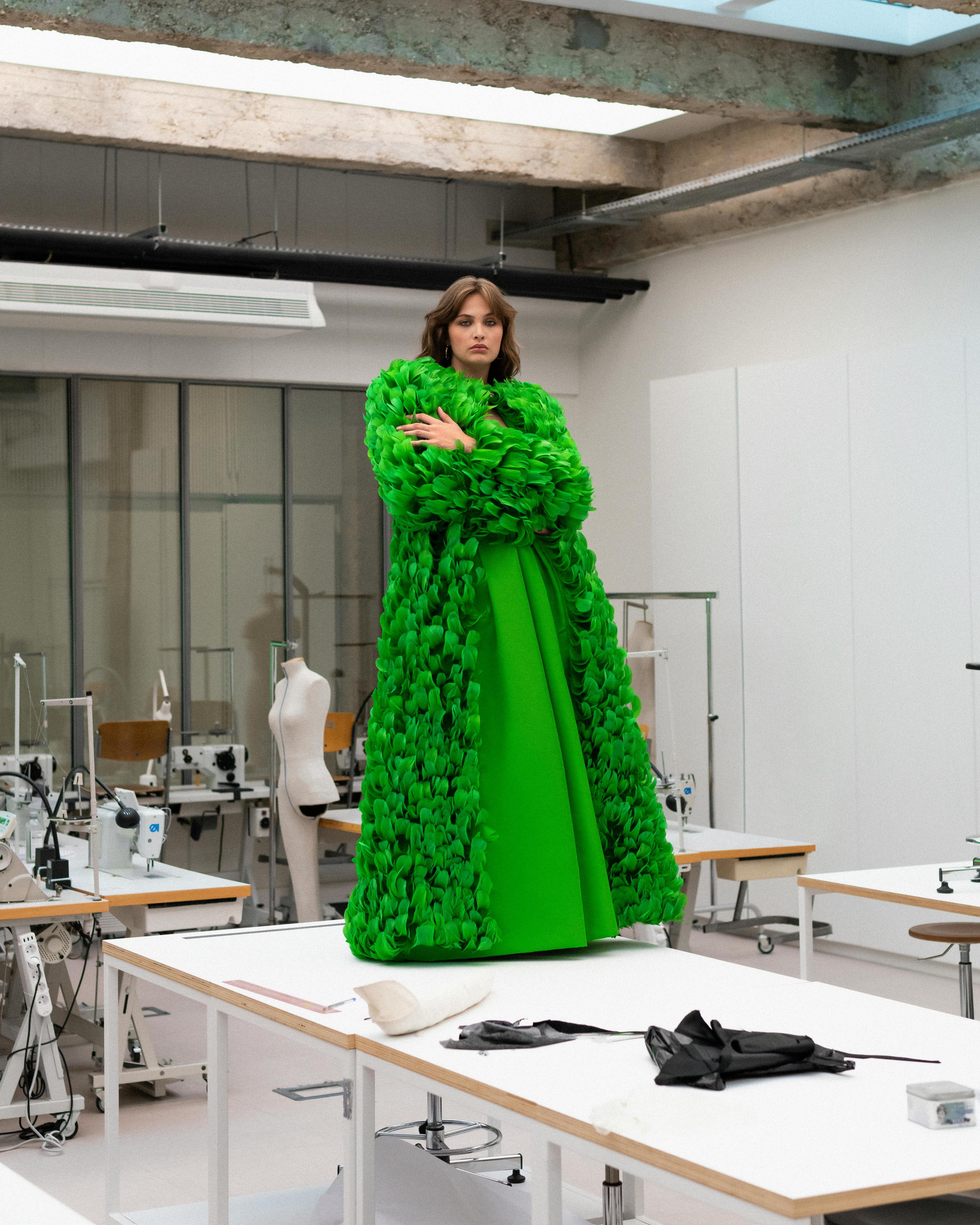 Cappotto over completamente ricamato di piume e pantaloni di faille di seta, GIAMBATTISTA VALLI HAUTE COUTURE; orecchini, VILTIER