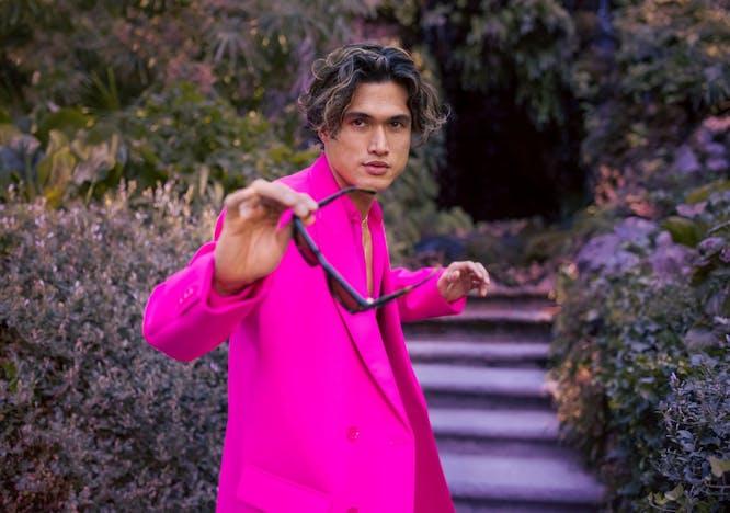 Charles Melton. Completo e gilet, VALENTINO PINK PP; occhiali da sole, VALENTINO GARAVANI.