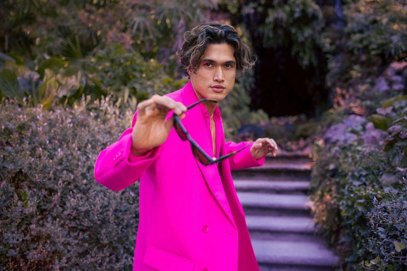 Charles Melton. Completo e gilet, VALENTINO PINK PP; occhiali da sole, VALENTINO GARAVANI.