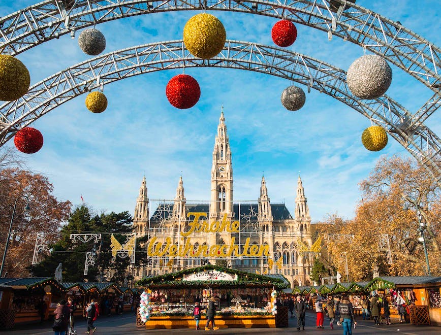 austrian christkindlmarkt city hall neues rathaus rathaus rathaus platz rathausplatz vienna wiener christkindlmarkt blue sky building buildings decorations exterior famous festive front gothic grand landmark landmarks landscape main market nobody on outdoor outside scene scenery stall stalls sunny day towers view city urban handbag bag arch architecture person shoe footwear gothic arch