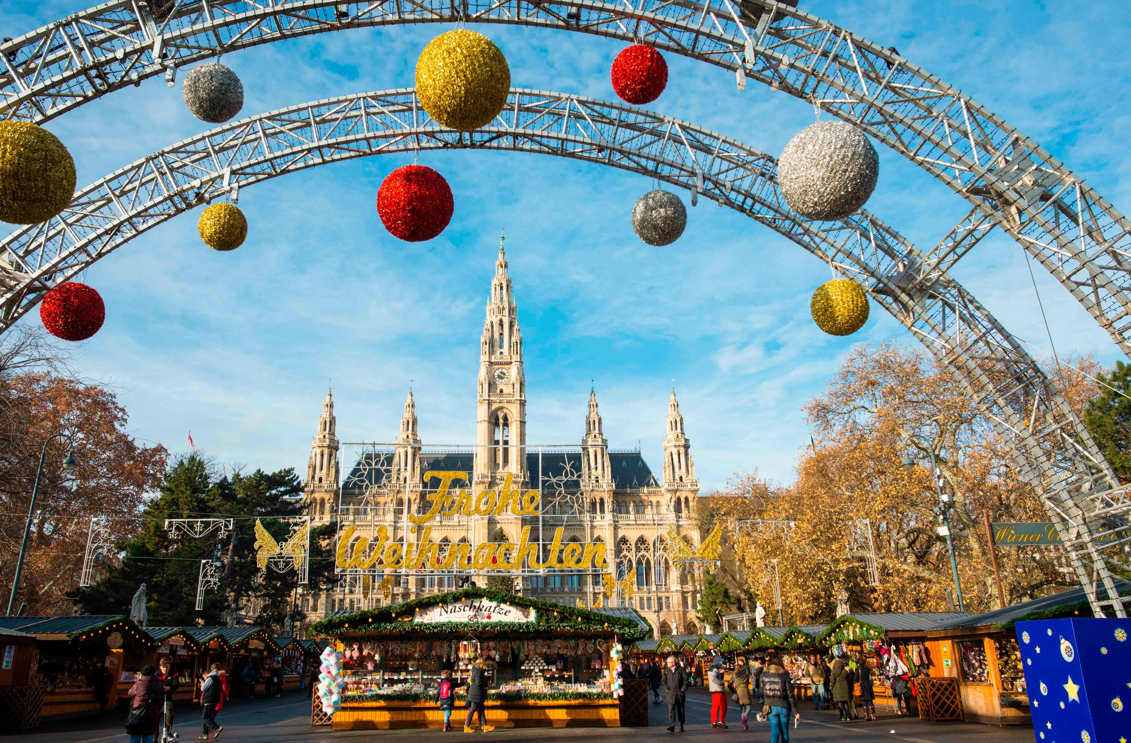 austrian christkindlmarkt city hall neues rathaus rathaus rathaus platz rathausplatz vienna wiener christkindlmarkt blue sky building buildings decorations exterior famous festive front gothic grand landmark landmarks landscape main market nobody on outdoor outside scene scenery stall stalls sunny day towers view city urban handbag bag arch architecture person shoe footwear gothic arch